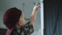 kid flying a toy airplane 