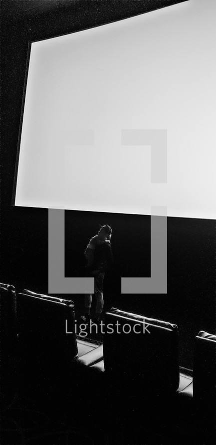 man standing in a dark auditorium 