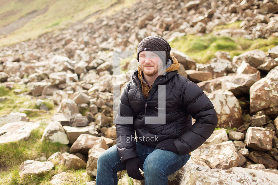 a man sitting on a rocky slope in Scotland 