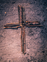cross made out of sticks in ashes
