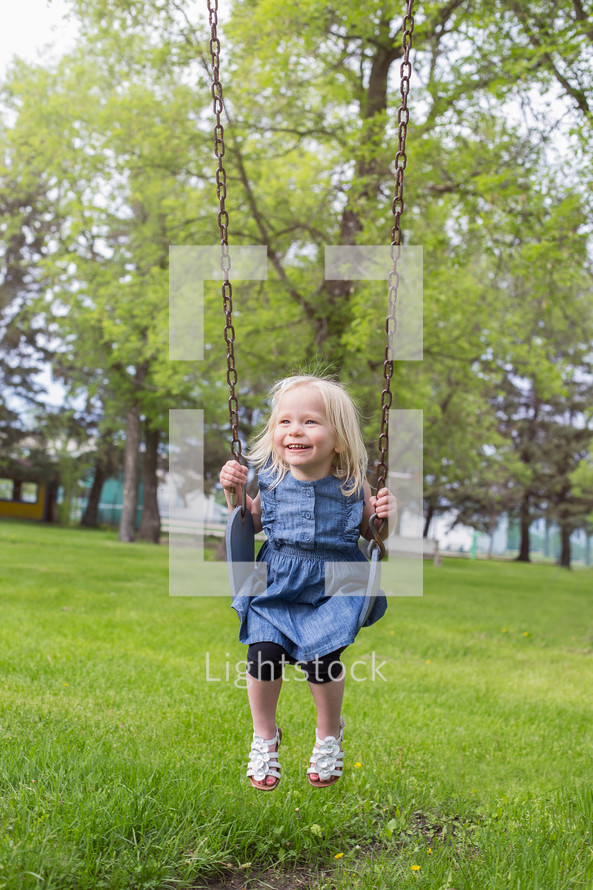 a toddler girl on a swing 