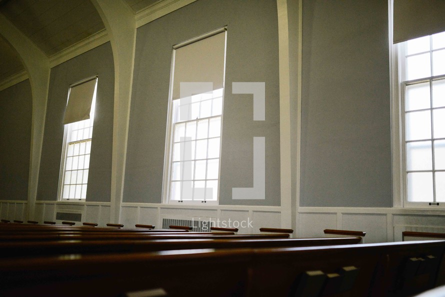 rows of church pews in an empty church 