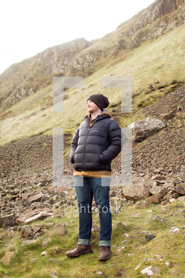 man standing on green slopes in Scotland 
