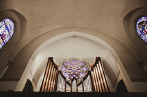The ceiling of a chapel - organ pipes fill the bottom of the photo