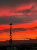 Silhouette of telecommunications tower at sunset
