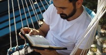 Man reading the Bible in a hammock chair