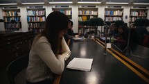a girl reading a Bible in a library 
