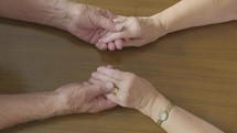 a couple holding hands across a table 