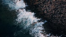 Waves crashing on a rocky shore, drone view