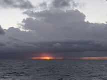 sunset over the ocean and a stormy sky 