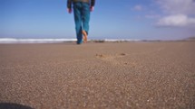 Man walk barefoot on sand beach in sunny morning nature, active outdoor travel
