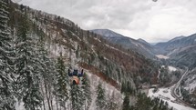 Paragliding flight above winter forest tress in mountains nature, Freedom fly adrenaline adventure Follow cam

