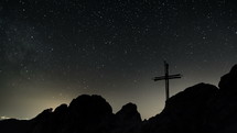 Time lapse of stars moving in night sky over cross
