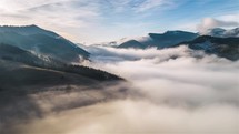 Foggy clouds are waving in early spring nature Aerial view of dreamy mountains landscape Timelapse
