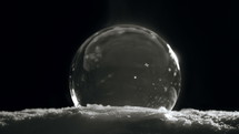 Freezing Christmas Ice Ball with flying snow flakes
