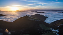 Colorful sunrise morning above mist clouds flows in mountain valley time lapse
