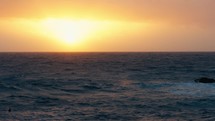 sun sets over stormy ocean