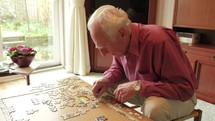 elderly man working on a puzzle 