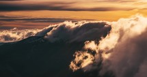 Misty clouds motion fast over alpine mountains ridge nature at sunrise Time lapse
