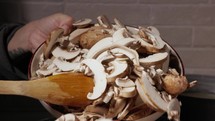 Cooking Mushroom - Pouring Mushroom Slices On Pan With A Wooden Spoon. - close up shot