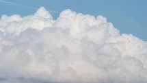 Time lapse of towering cumulus clouds billows in summer sky 

