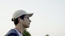 man walking outdoors listening to earbuds 