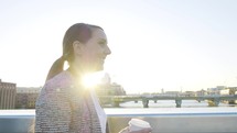 a woman walking and drinking coffee outdoors 