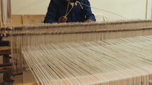 Man weaving on a hand loom  in a textile workshop
