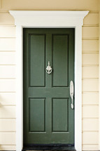 A green door with a door knocker.
