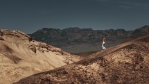 Tourist girl walking down a mountain in Death Valley