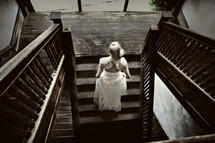 bride walking up wood staircase 