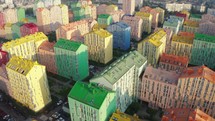 Cityscape with multicolored houses, cars on the street. Top down view, drone video footage
