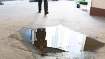reflection of a businessman in a puddle 