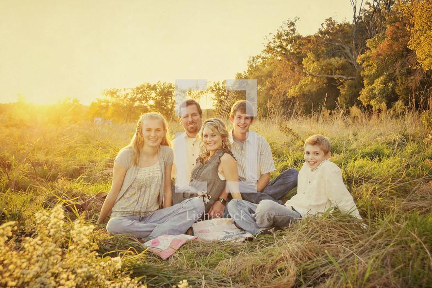 Happy family sitting in grass field