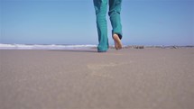 Man walk barefoot on sand beach in sunny ocean coast nature, slow motion outdoor travel
