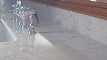 Tracking shot of a silver faucet in a luxury kitchen