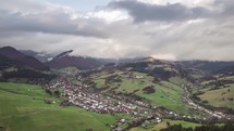 Fly over small village time lapse. Aerial hyper-lapse with fast moving clouds

