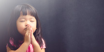a little girl in prayer 