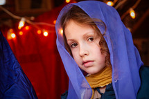 a little girl dressed as Mary in a live nativity scene 