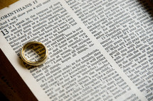 wedding band over the word Love in a Bible