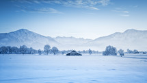 mountains behind a barn in snow 
