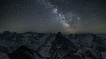 Beautiful starry night sky with milky way galaxy stars over winter alps mountains

