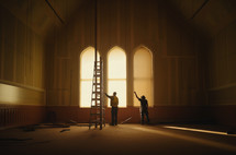 Building for Jesus. Two workers working on the interior
