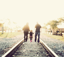 family walking on railroad tracks 