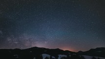 Starry night Time lapse Milky way galaxy astronomy stars moving over mountain forest, Night to day
