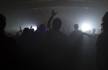 silhouette of raised hands of an audience at a concert 