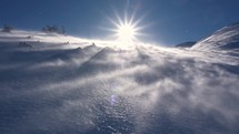 Panorama of frozen winter alps mountains with snow blown by strong wind in windy nature, low angle view
