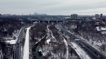 Aerial shot of Bayview Ave, Don Valley Parkway and Don River in urban dynamic Toronto on a cold winter day. Aircraft is approaching Prince Edward Viaduct while showing moderate vehicular traffic. 