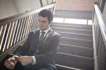 groom sitting in a stair way before his wedding