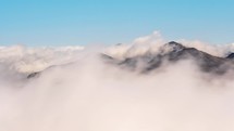 Low clouds moving fast in New Zealand mountains landscape in sunny summer day Time-lapse
